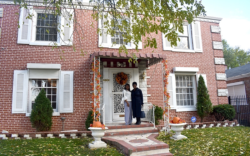 brick house with owners on front steps