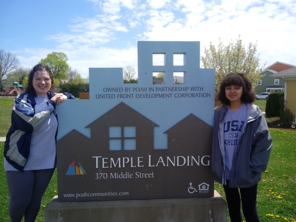 Fraces & Ryjani standing at temple landing sign 